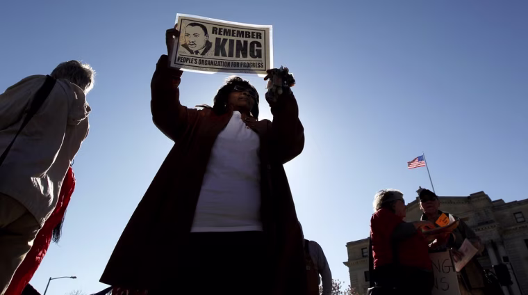 Elgie Hayes holds a sign during a rally in remembrance of Rev. Martin Luther King Jr. on April 4 in Newark, N.J.