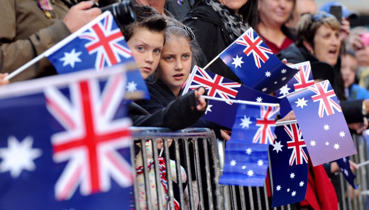 Children watch veterans march through Sydney streets as tens of thousands of Australians and New Zealanders gathered on April 25, 2012 to honor their war dead, attending sombre dawn services and veterans parades in memory of those who fought in war.