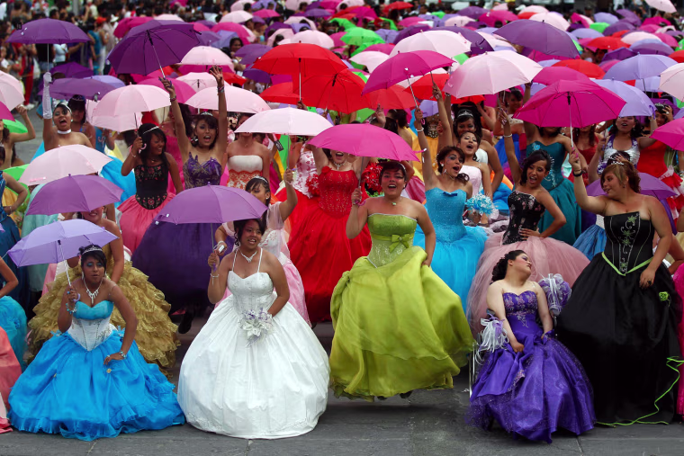 Girls dressed in evening gowns pose for photographs at Zocalo square in Mexico City.