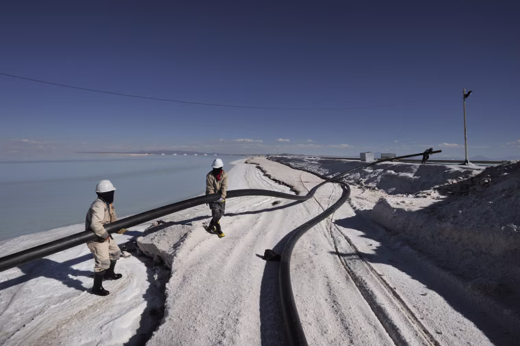 Workers at the experimental evaporation plant where the lithium is extracted bring tubes from the well to the basins. Workers are from different parts of Bolivia.