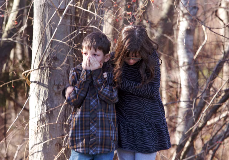 Young children wait outside Sandy Hook Elementary School after the shooting in Newtown, Conn., on Friday.