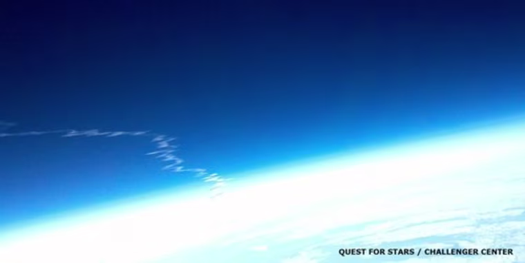 The trail of exhaust left behind by the shuttle Discovery begins to dissipate in the atmosphere, as seen in this view from the Robonaut-1 high-altitude balloon. The image was captured using a Motorola Droid X smart phone.