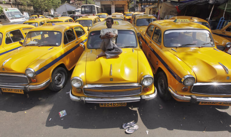A driver rests on his iconic yellow ambassador taxi during a country-wide strike in the eastern Indian city of Kolkata February 28, 2012. Hundreds of thousands of workers from several trade unions went on strike across India on Tuesday to express their anger at soaring prices and to back demands for improved rights for employees, trade unions said. REUTERS/Rupak De Chowdhuri (INDIA - Tags: BUSINESS POLITICS EMPLOYMENT)
