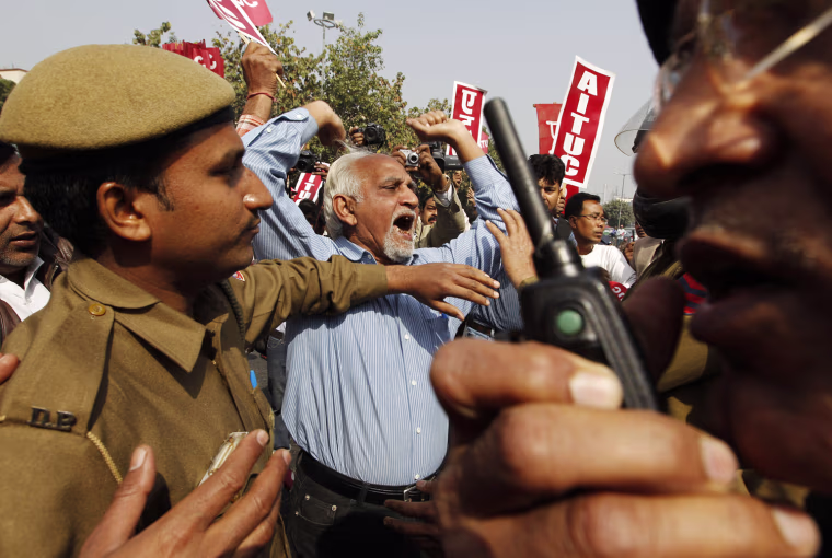 Policemen enter into a scuffle with trade union activists as the activists block a major intersection as part of a countrywide industrial strike in New Delhi, India, Tuesday, Feb. 28, 2012. Shops and banks were closed, factories shuttered and traffic sparse in major cities across India during an industrial strike Tuesday called by trade unions against the government. Eleven major trade unions called for the strike to protest against rampant inflation. (AP Photo/Saurabh Das)