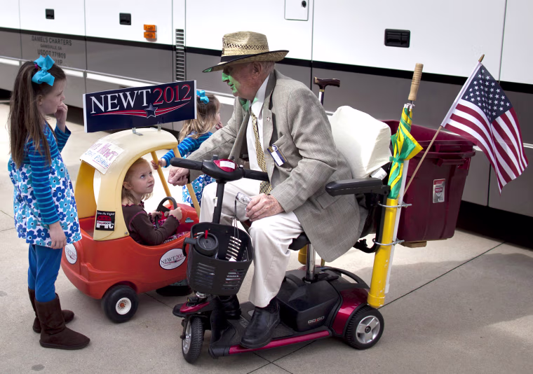 Ray Battle of Cedartown, Ga., right, talks with, from left, Molly Clemmons, 6, of Rome, Ga., Kileigh Barcomb, 5, of Rome, Ga., and Katie Clemmons, 2, of Rome, Ga., before a rally for Republican presidential candidate, former House Speaker Newt Gingrich on Tuesday, Feb. 28, 2012 in Rome, Ga. (AP Photo/Evan Vucci)
