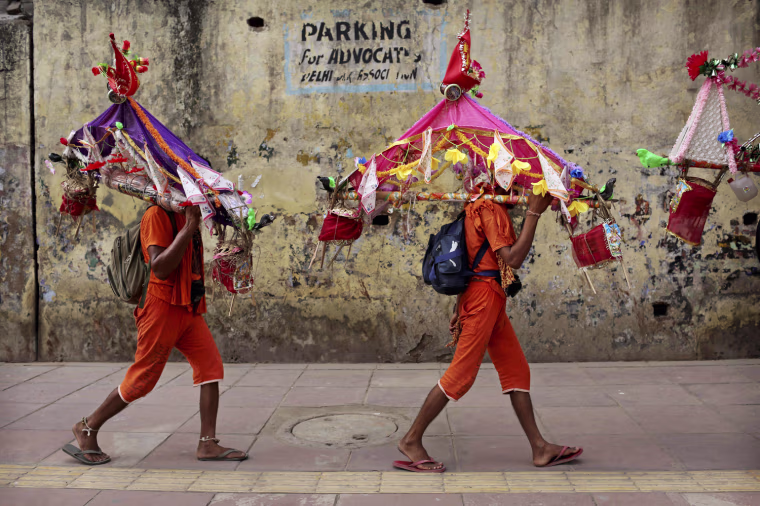 Kanwarias carry water from the River Ganges in New Delhi, India on July 10, 2012.