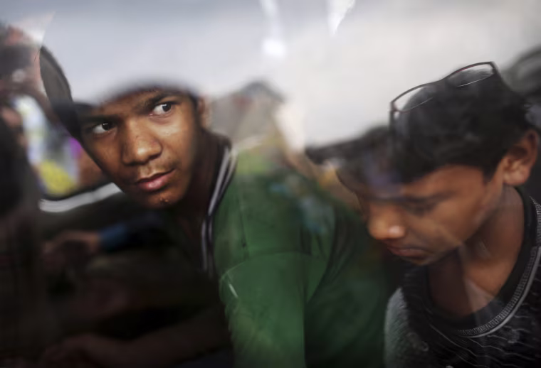 Indian bonded child laborer Mohammad Wasim, 13, left, sits in a vehicle after being rescued during a raid on July 11, 2012.