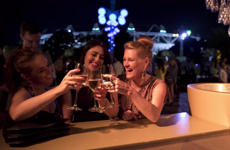 Anna Celeste Walters, left, has a toast with her friends Amy Loudon, center, and Alex Sinclair. They were three of about a thousand people who celebrated the opening ceremonies at Forman's Smokehouse, a family-run fish processing company in East London.