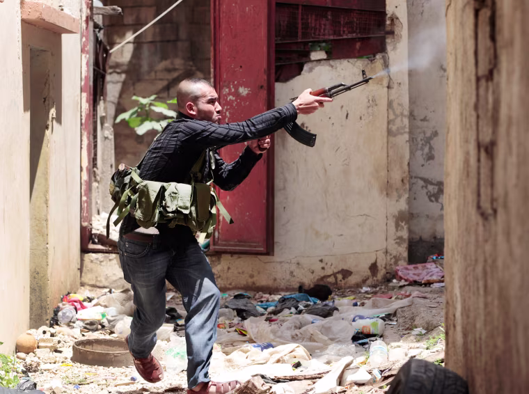 A Sunni gunman fires during clashes, in the northern port city of Tripoli, Lebanon, on May 14. Street battles pitting Lebanese Sunnis who generally support the Syrian uprising, against Alawite supporters of Assad's regime killed at least one person Monday, raising the death toll to four since Sunday. The clashes began Sunday after authorities detained an anti-Syrian Lebanese national.