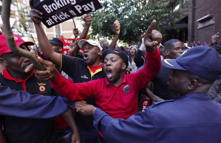 A policeman keeps watch as angry COSATU supporters chant slogans during a march by the Democratic Alliance (DA) South Africa's main opposition party in Johannesburg, May 15. The march by South Africa's main opposition party on the headquarters of leading union federation COSATU descended into chaos on Tuesday, with police firing tear gas to disperse crowds of rock-throwing protesters.
