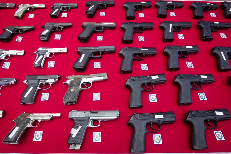 Weapons confiscated by the police are displayed during a news conference in Caracas.