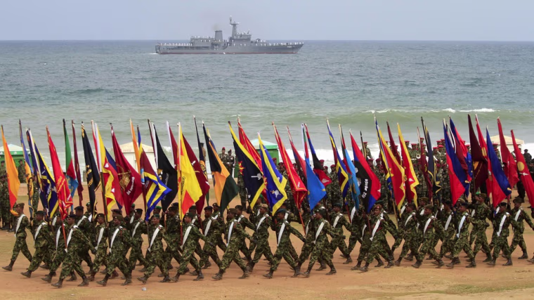 Sri Lankan army soldiers carry flags of their respective units during the annual victory day parade.