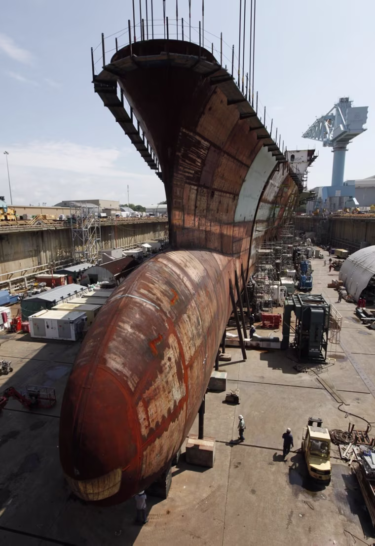The lower bow section of the nuclear powered aircraft carrier Gerald R. Ford is lowered into position at Newport News Shipbuilding.