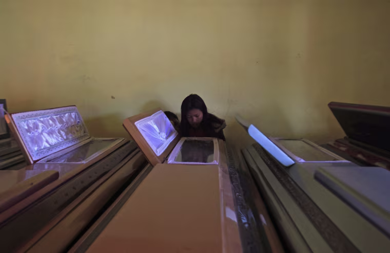 A woman looks at one of the coffins of the ten members of the Vazquez Gomez family killed in the earthquake in San Cristobal Cucho, about 155 miles south of Guatemala City on Nov. 8, 2012.
