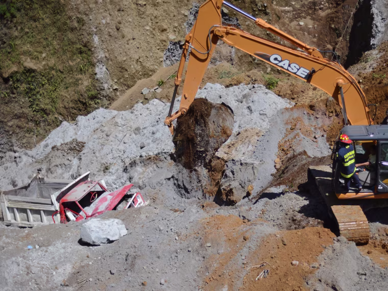 Firefighters use heavy equipment to search for people feared buried at a sand mine in San Marcos, Guatemala, on Nov. 8.