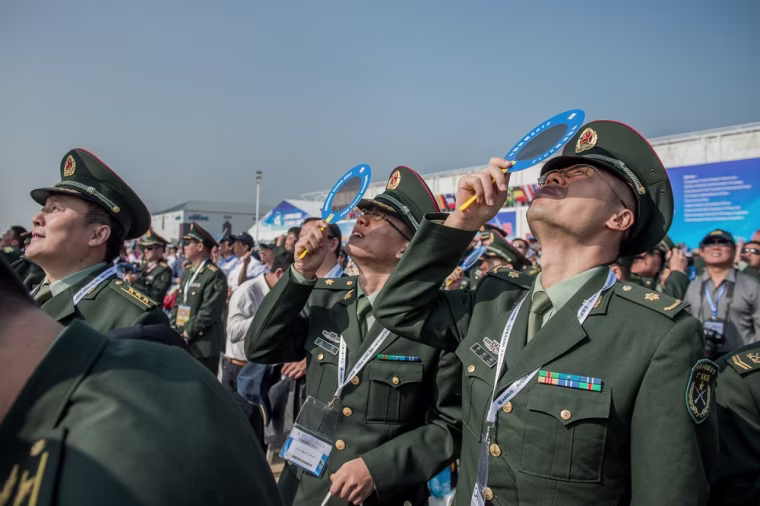 Officers of China's People Liberation Army watch planes performing during the 9th China International Aviation and Aerospace Exhibition in Zhuhai on November 13, 2012.