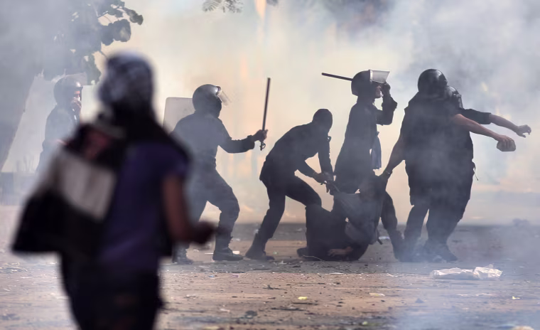 Egyptian security forces arrest a protester during clashes near Tahrir square in Cairo, Nov. 27, 2012.