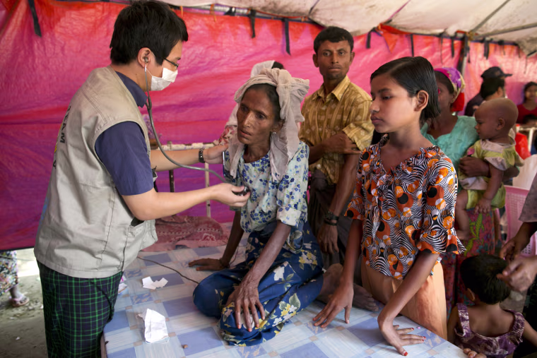 Kyaw Tin examines a woman named Mumtaz at a government-run medical clinic on the outskirts of Sittwe, Myanmar, Nov. 25. Mumtaz was later taken to a local hospital.