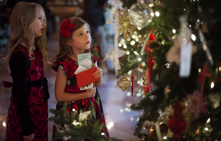 Lauren Rae, left, and Olivia Marlow look at the ornaments on a Christmas tree in the Grand Foyer during the first viewing of the White House 2012 holiday decorations. The first lady welcomed military families to the White House for a viewing of the decorations.