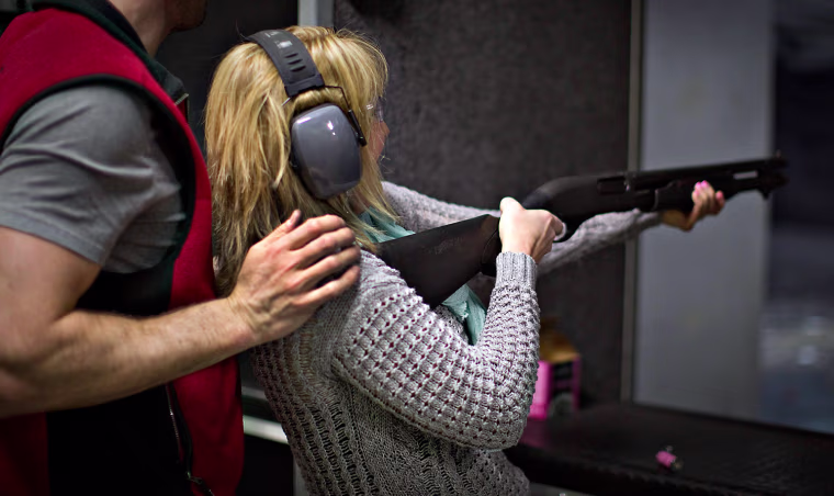 A range officer holds a woman steady while she fires a shotgun at the DVC Indoor Shooting Centre in Port Coquitlam, British Columbia on March 22. The DVC is the only indoor shooting center in the province that rents firearms to the public without a license.