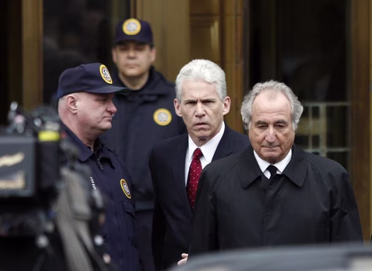 Bernard Madoff, right, exits the Manhattan federal courthouse in New York in this March 10, 2009, file photo. Madoff says through his efforts, victims could be repaid all their original principal. He also claims he has information that