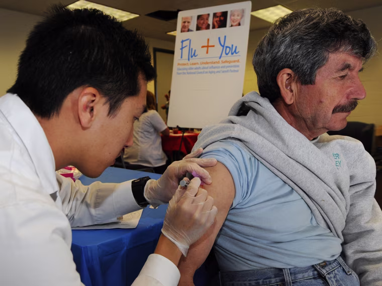 IMAGE DISTRIBUTED FOR NATIONAL COUNCIL ON AGING AND SANOFI PASTEUR - Pharmacist Jason To gives a flu shot to Joao Ferreira during the Flu You event ...