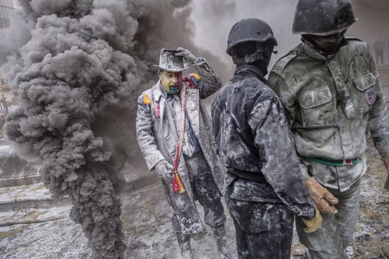 Revellers in mock military uniforms take part in the battle of 'Enfarinats,' on Saturday in Ibi, Spain.