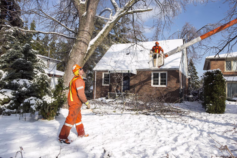 A crew works to restore power to a house in Scarborough, Ontario, on Friday.