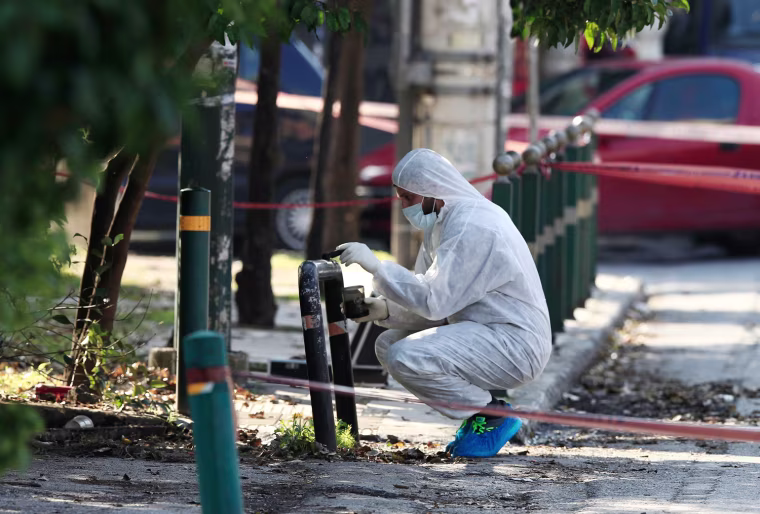 An anti-terrorism police officer investigates outside the residence of German ambassador to Athens, Wolfgang Dold, in the northern suburb of Halandri on Monday.