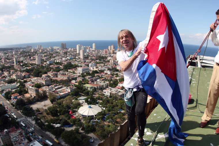 Robert celebrates atop the hotel with the Cuban national flag.