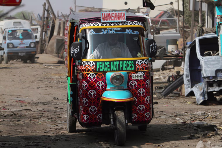 A rickshaw driver, his vehicle adorned with a message of peace, makes his way through the slums of Karachi, Pakistan on Feb. 2, 2013.