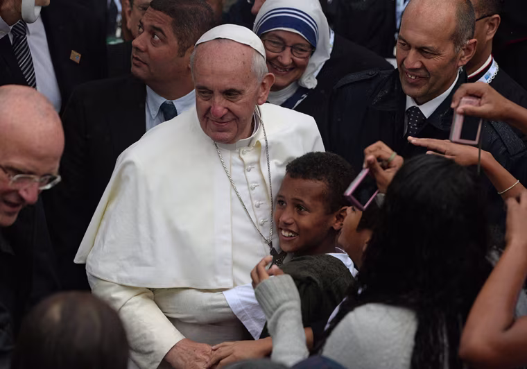 Pope Francis is hugged by a boy at the Sao Jeromino Emiliani church during his visit to the Varginha favela in Rio de Janeiro, Thursday.