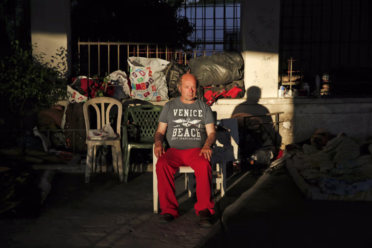 Giorgos, 50, sits with his belongings under a bridge, where he lives with a group of other homeless people, in central Athens on May 25, 2013. Giorgos was forced to close down the billiard hall he owned in 2006 and spent time in prison for not paying his social security debts.