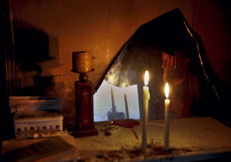Tareq, a 46-year-old unemployed painter, is reflected in a mirror in the shed where he lives at an abandoned factory in central Athens on May 30, 2013. Tareq, a Syrian refugee, who lived in Greece during the 1990s, returned to Syria, but fled back to Greece in 2012, to escape the violence there.