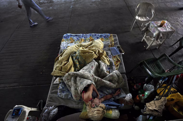 Marialena, a 42-year-old homeless AIDS sufferer and former drug addict who is on a methadone rehabilitation program, sleeps under a bridge in central Athens on May 13, 2013.