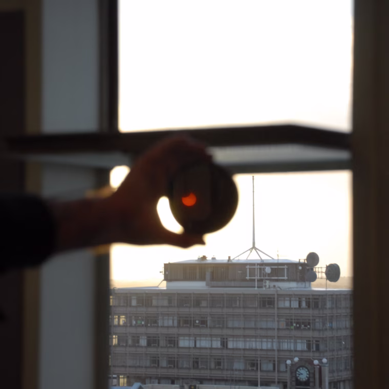 The partially eclipsed sun can be seen through a filter held in front of a seventh-floor window in Invercargill. Appropriate safety protection, such as specially designed solar filters, should always be used when gazing at the sun, even during a partial eclipse.