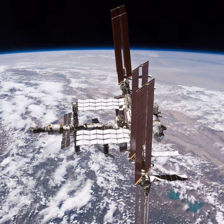 Earth spreads out nearly 250 miles (400 kilometers) below in the background of this unusual view of the International Space Station.
