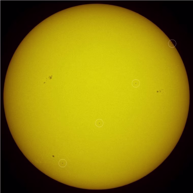 A four-image composite tracks Atlantis' transit across the sun's disk, just 21 minutes before today's deorbit burn. The white circles highlight Atlantis.
