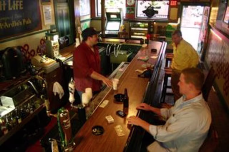 Bernie Rafferty, behind the bar, thinks minimum charges are a good idea