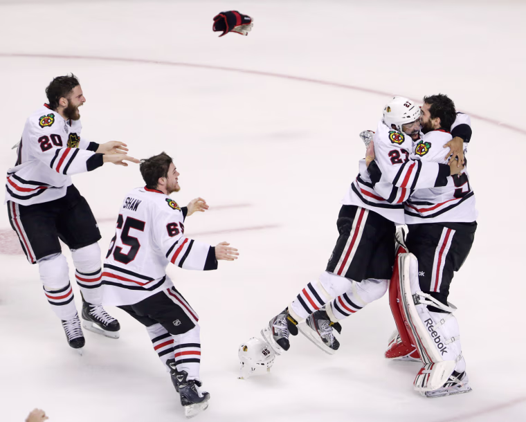 Chicago Blackhawks defenseman Johnny Oduya (27), of Sweden, hugs Chicago Blackhawks goalie Corey Crawford (50) after winning Game 6 of the NHL hockey Stanley Cup Finals 3-2 against the Boston Bruins, on June 24, 2013, in Boston.