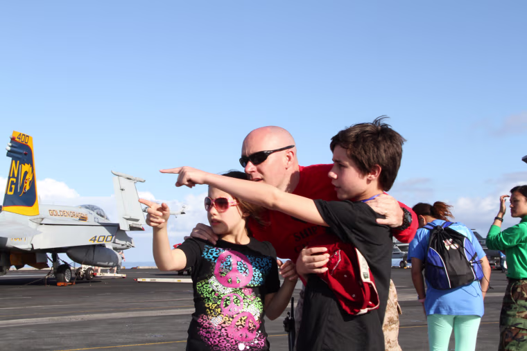 The Lemons family, Samantha, Michael, and Micheal Jr., watch the Navy's air power demonstration aboard the USS John C. Stennis.