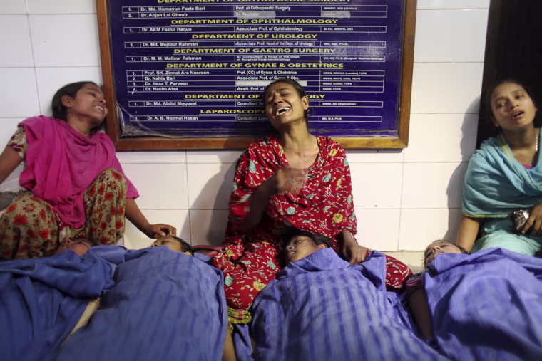 Relatives mourn beside bodies in front of a hospital gate following a fire at SMART factory in Dhaka, Bangladesh, on Jan. 26, 2013. At least seven garment workers died and many more were injured in a stampede after a fire broke out in the factory.