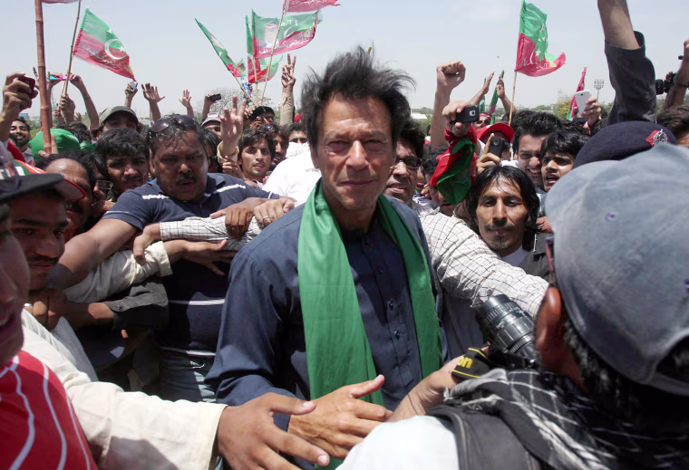 Former cricket star Imran Khan (center) is mobbed by supporters at a rally in Karachi, Pakistan, on Tuesday.