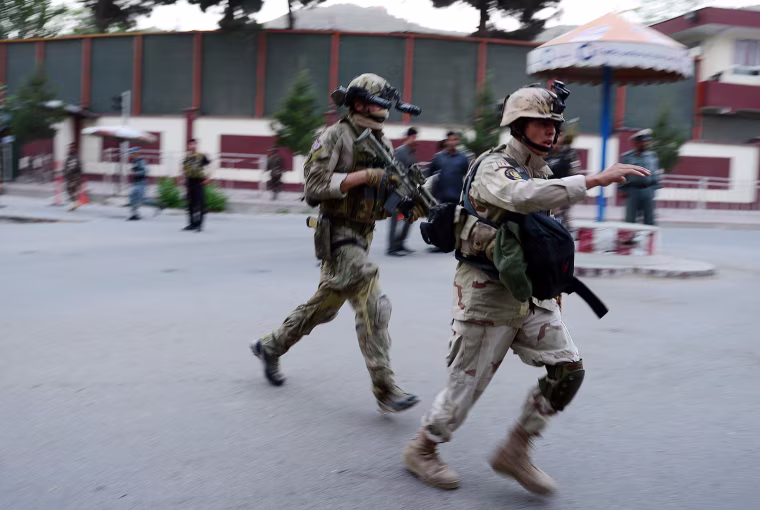 A Norwegian Special Force officer (center) follows an Afghanistan MOI Special Force member to the site of a clash between Afghanistan security forces and Taliban fighters in Kabul on May 24, 2013.