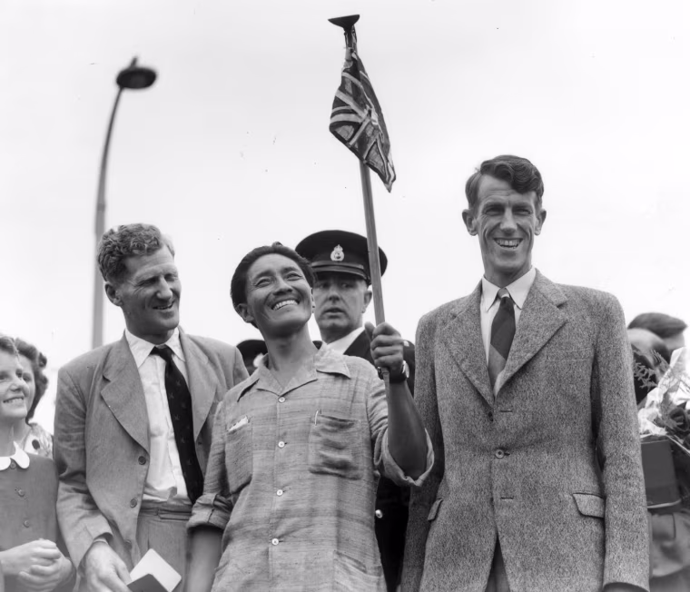 Sir Edmund Hillary and Nepalese Sherpa Tenzing Norgay became the first to reach the summit of Mount Everest on the Nepal-Tibet border 9,028 feet up, after an exhausting climb up the southern face. On July 3, 1953 Tenzing Norgay, center, and Edmund Hillary, right, make a jubilant return to Britain after becoming the first men to scale Mount Everest.