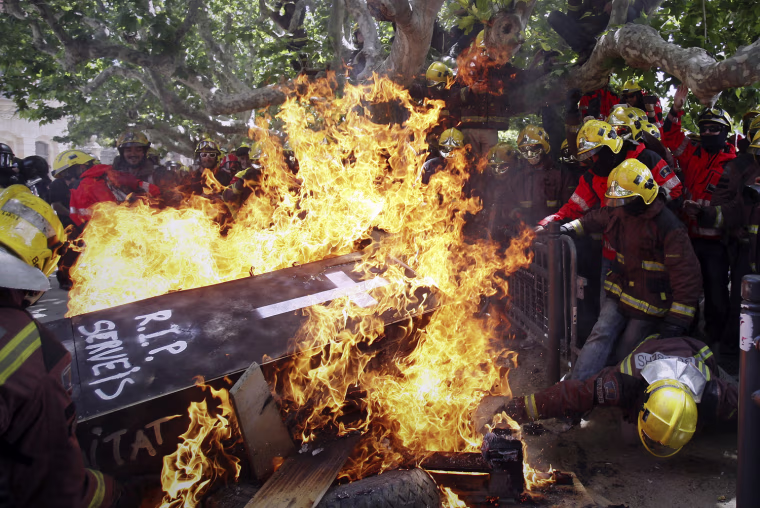 Firefighters burn a mock coffin bearing the words