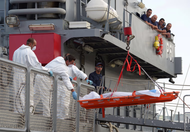 Maltese rescue workers lower the corpse of a migrant from a patrol boat of the Armed forces of Malta at Hay Wharf in Valletta Saturday.