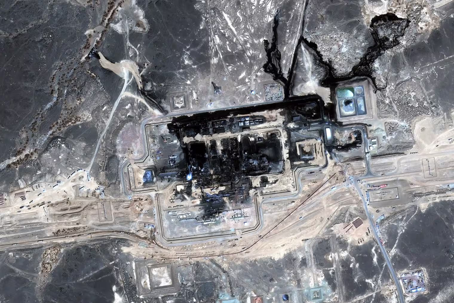 A satellite image of a charred factory complex in the desert.
