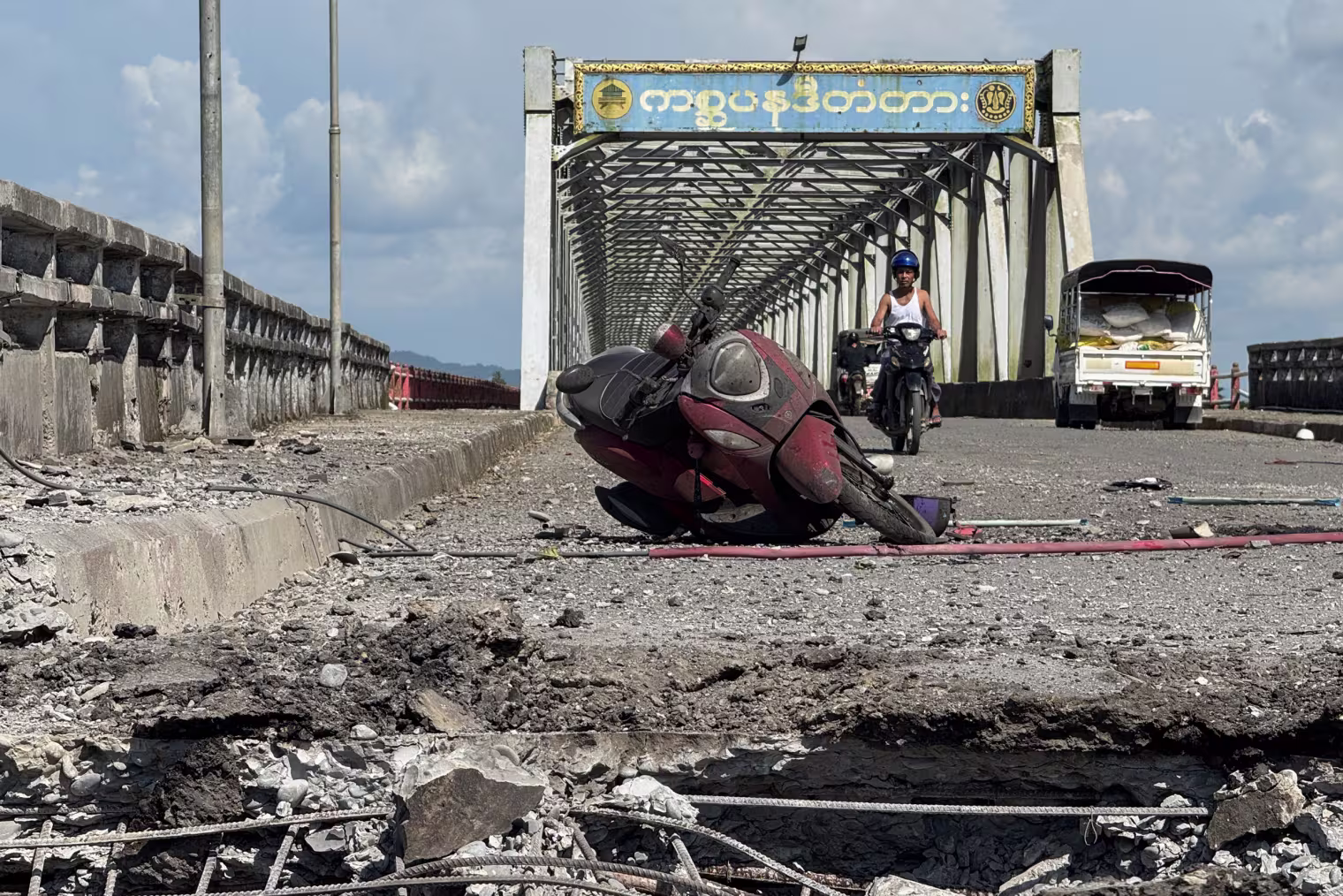 A damaged motorcycle sits on the Kisapanadi Bridge.