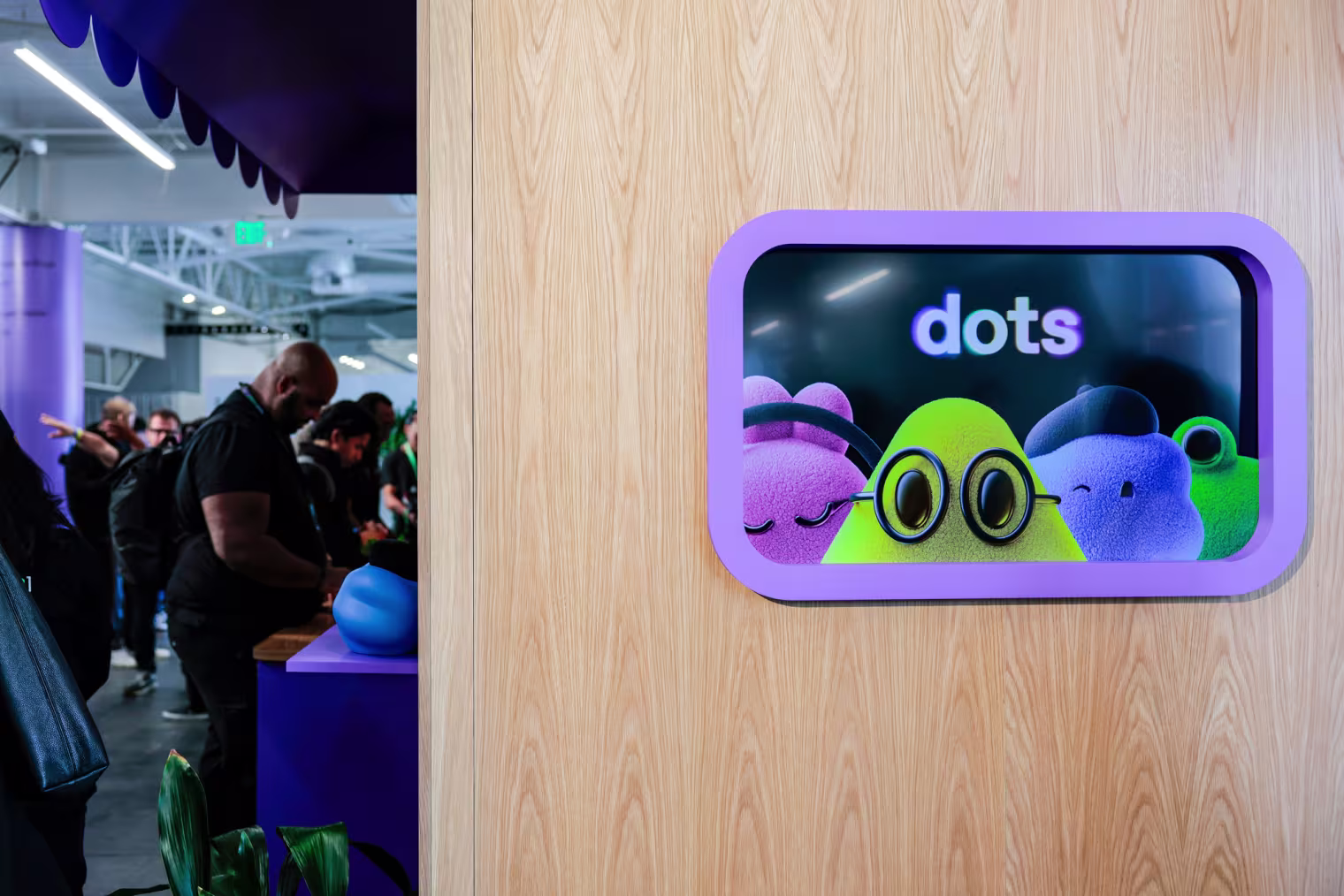 A sign for "dots", virtual AI agents shaped like blobs of different colors wearing glasses, berets, and headphones
